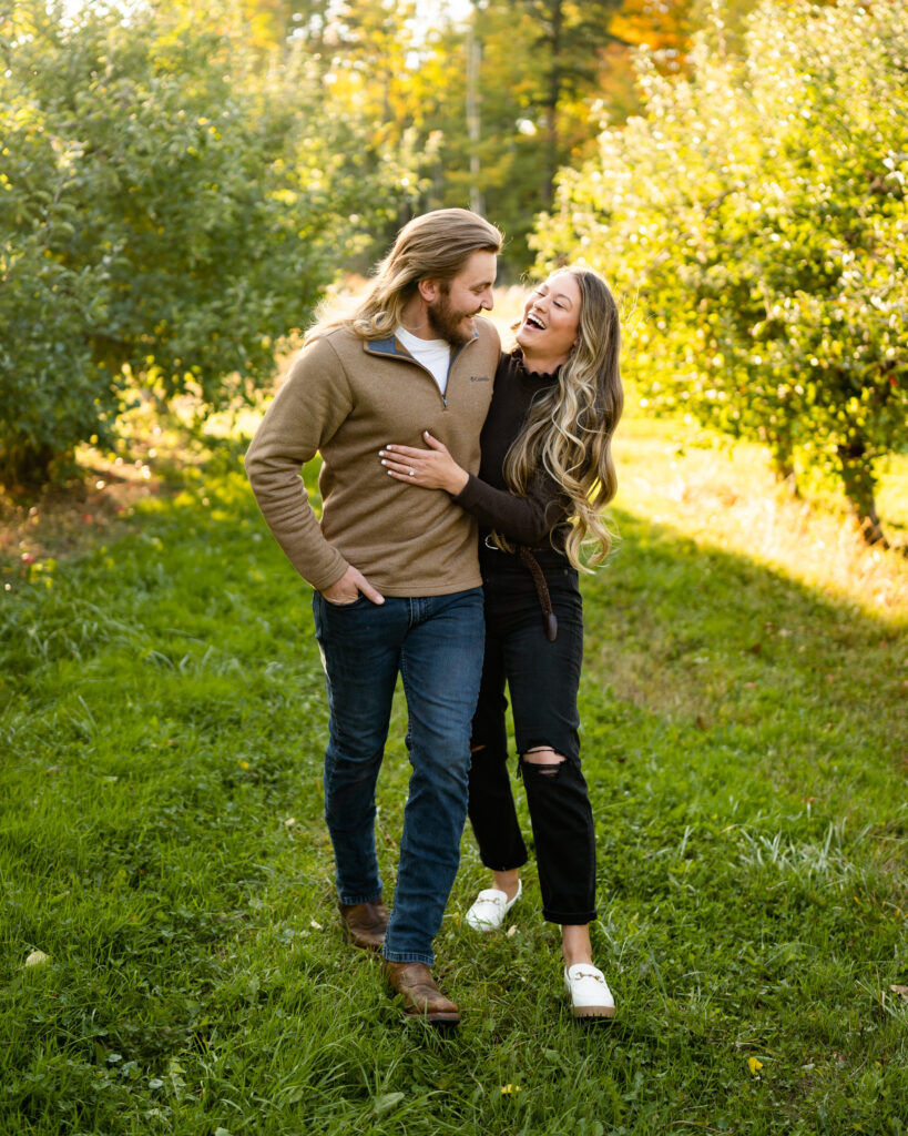 Engaged couple taking a romantic walk through a beautiful orchard
