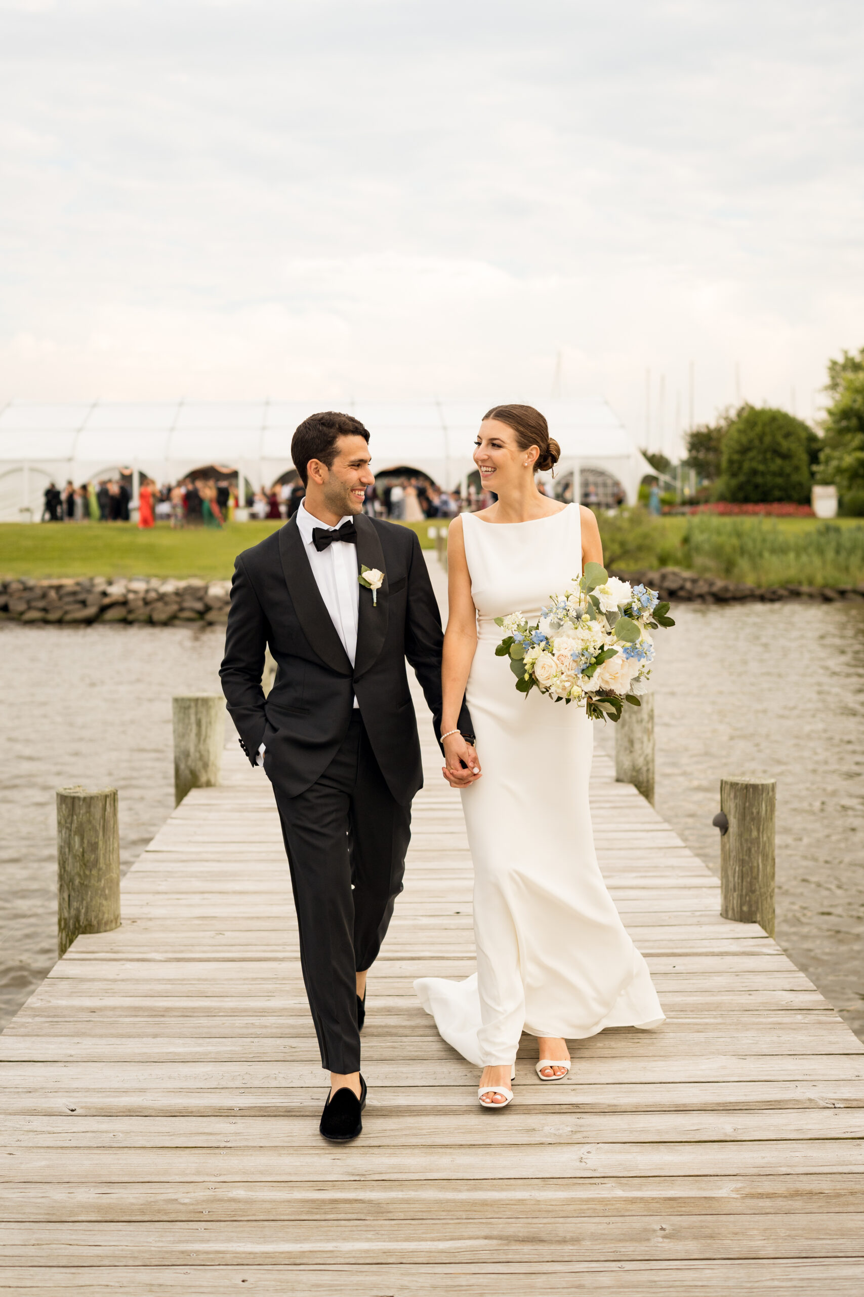 Emma and Fady had their traditional wedding ceremony and reception at the Polynesian Lawn and Paradise Ballroom at Herrington on the Bay. Herrington is a coastal wedding venue on Chesapeake Bay. These photos show the happy couple on the dock at the venue, with their reception space in the background.