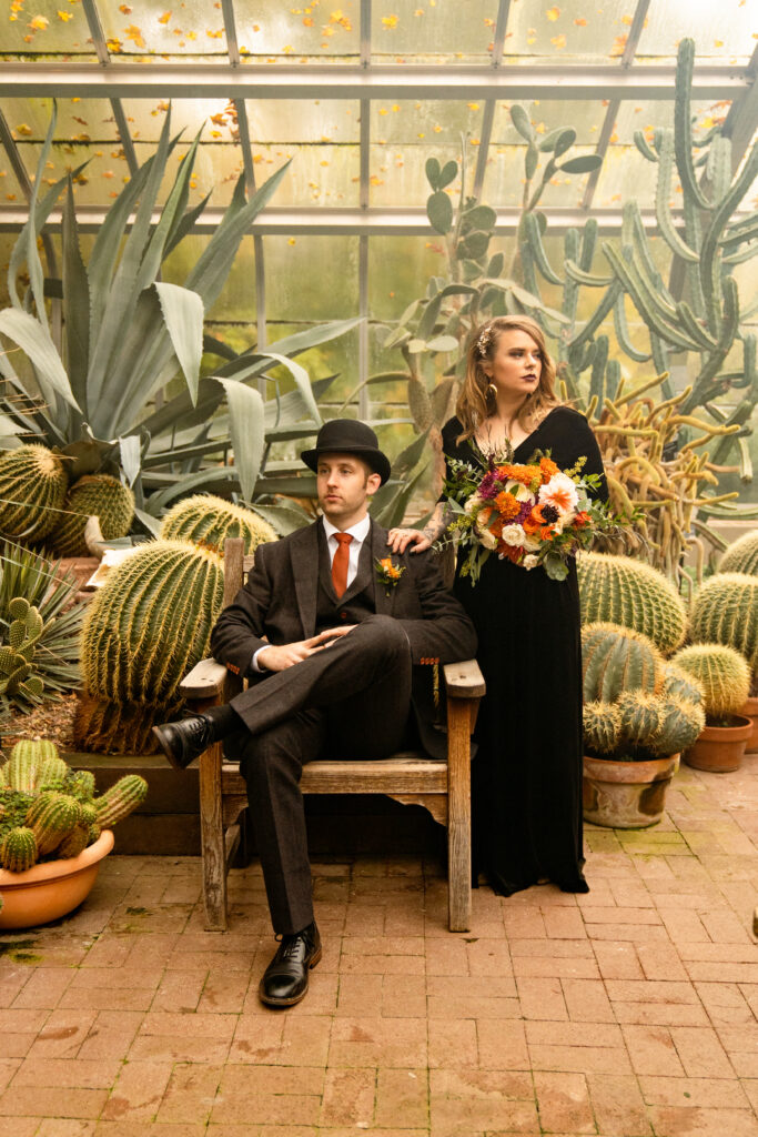 A bride and groom in their wedding attire pose for portraits inside the lush cactus room of the Lamberton Conservatory in Highland Park.